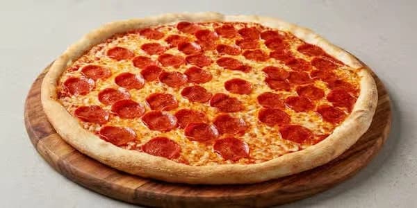 A New York, New York pizza, double dry-cured pepperoni on the pan at the table